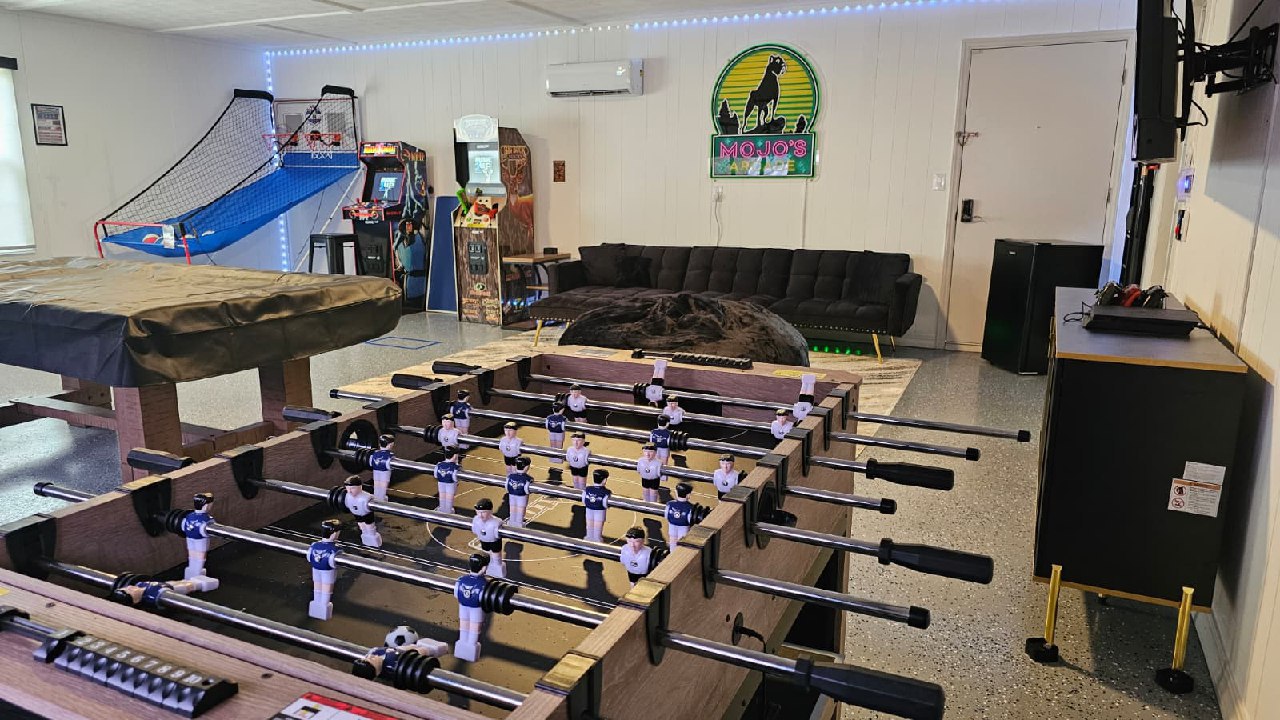 Foosball table and covered pool table with Mojo's Arcade sign